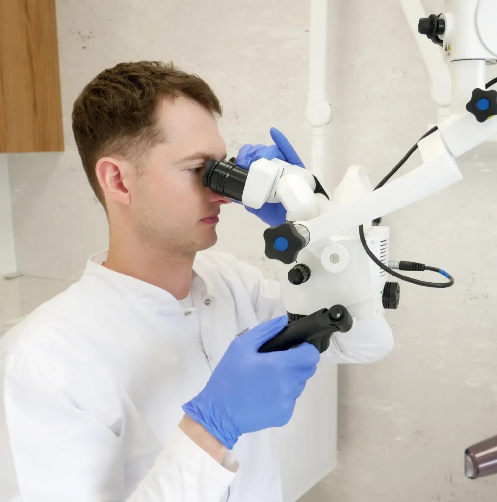 Doktor Patryk Spurek podczas wykonywania zabiegu leczenia kanałowego pod mikroskopem